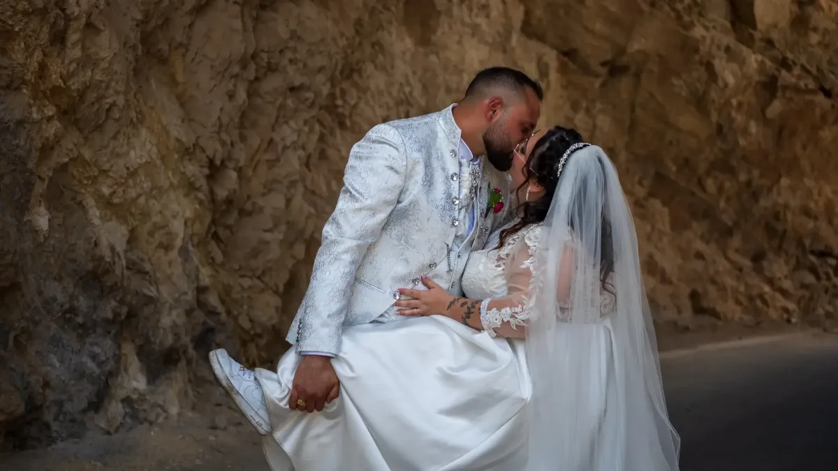 Beso de novios en ceremonia | Fotógrafo en Almería y Granada Fotógrafo de eventos en Almería; pareja de novios besándose tras la ceremonia en formato vertical