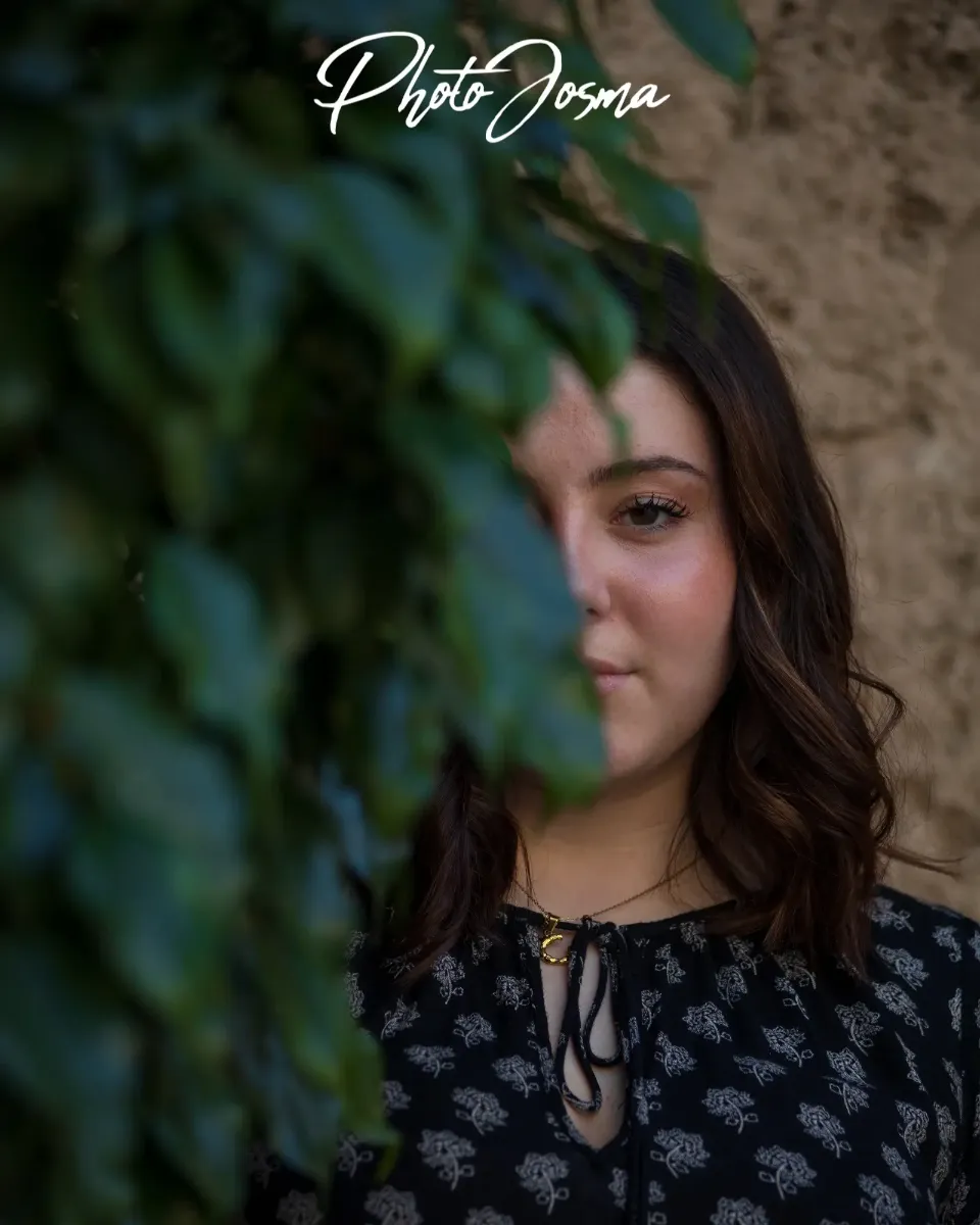 Chica mirando a cámara detrás de un arbusto Chica mirando a cámara detrás de un arbusto